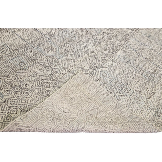 Beautiful modern Apadana's Safi Collection hand-knotted wool rug with a beige color field. This Modern rug has gray...