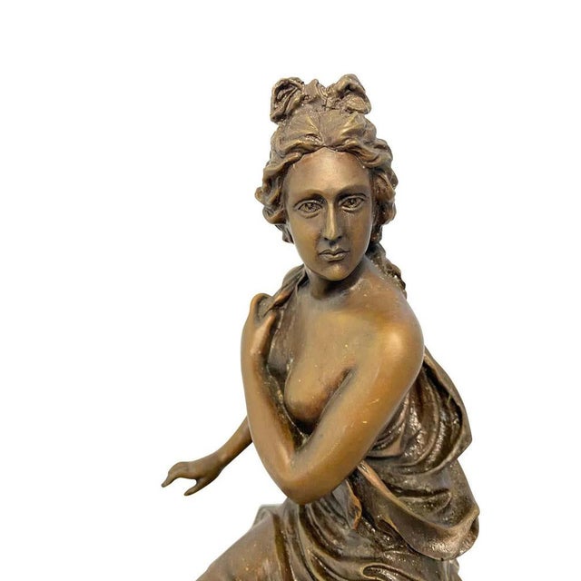 A neoclassical style bronze lady on detailed plinth base, 20th century. The styled sculpture of a striking, semi-nude...