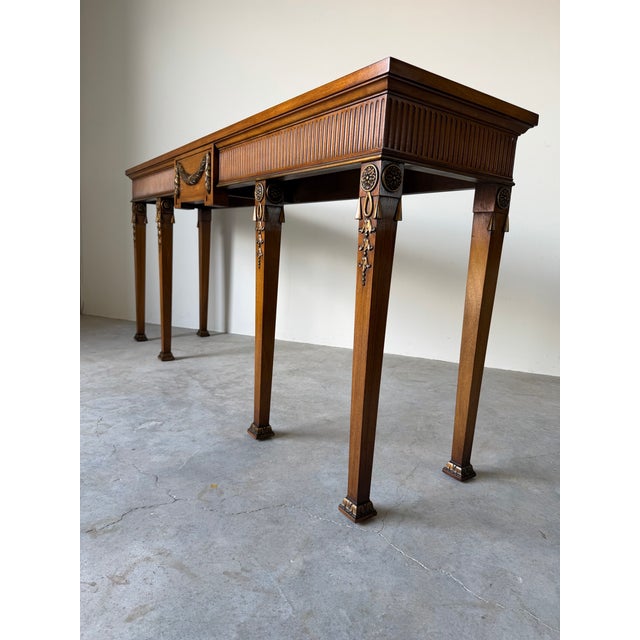 This elegant vintage Neoclassical style console table is beautifully crafted from solid mahogany and features exquisite...