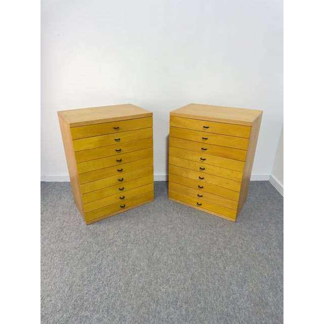 Set of 2 modular chests of drawers/filing cabinets, 1980 Each wooden chest of drawers has 9 drawers featuring classic...