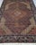 The central medallion of this hand-knotted rug commands the room before anything else does. A large diamond form in ivory...