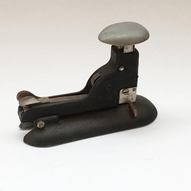 This is a black and silver metal Hotchkiss No. 6 stapler. The staples are loaded and removed from the back where a two...