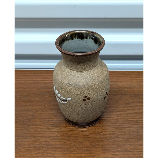 This Mexican ceramic features a striking hand-painted floral design in rich browns, greens, and blacks.