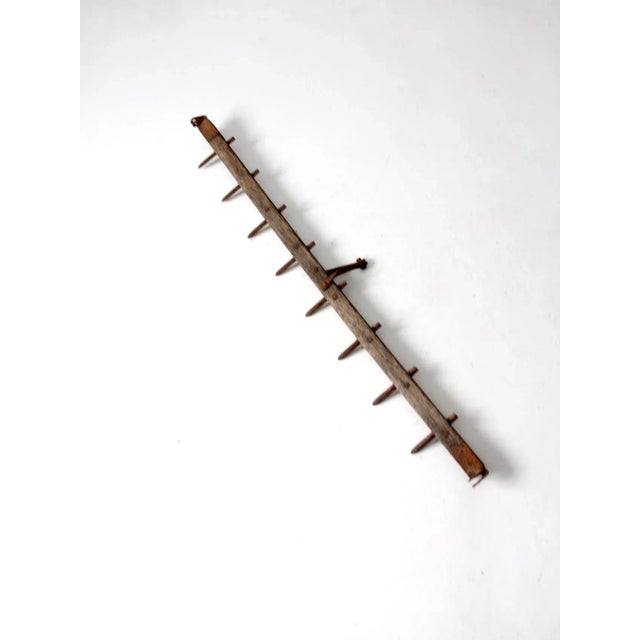 This is an antique spike tooth harrow, an early farm tool used to break up and smooth soil before planting. It features a...