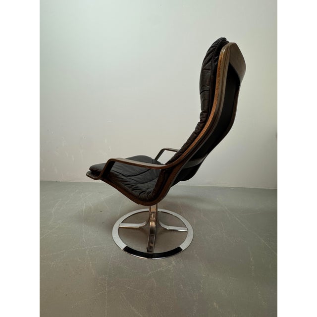 Swedish mid-century swivel lounge chair model T213 by Göte Möbler Nässjö. Upholstered in smooth black leather and mounted...