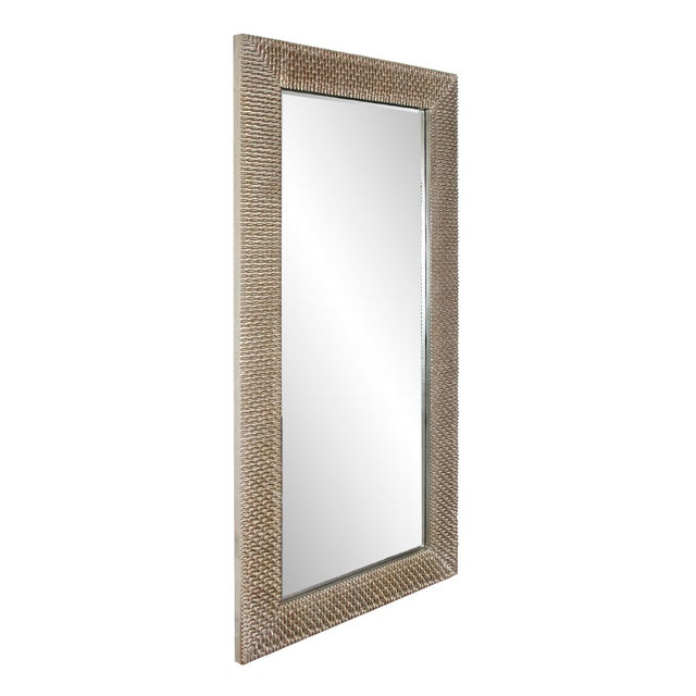 The Bergman Mirror features a round frame characterized by a textured ribbed design. It is then finished in a brushed...