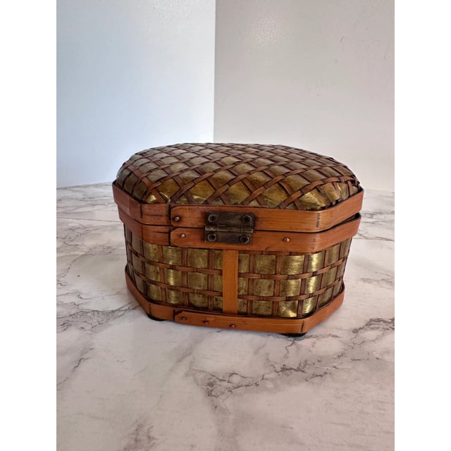 Hinged Box Basket with Brass Detail Lovely hinged lid woven basket-like chest. Made of woven natural fibers with pieces of...