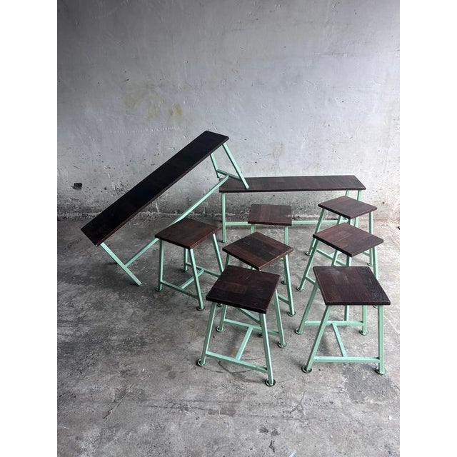 A striking vintage industrial seating set consisting of two benches and seven matching stools. Featuring mint green steel...