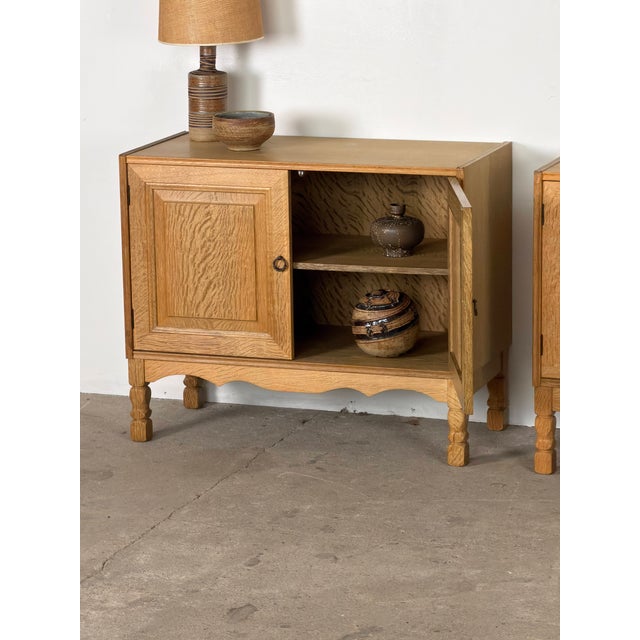 Pair of oak cabinets made in Denmark during the 1960s, each with a broad rectangular case raised on four shaped legs. The...