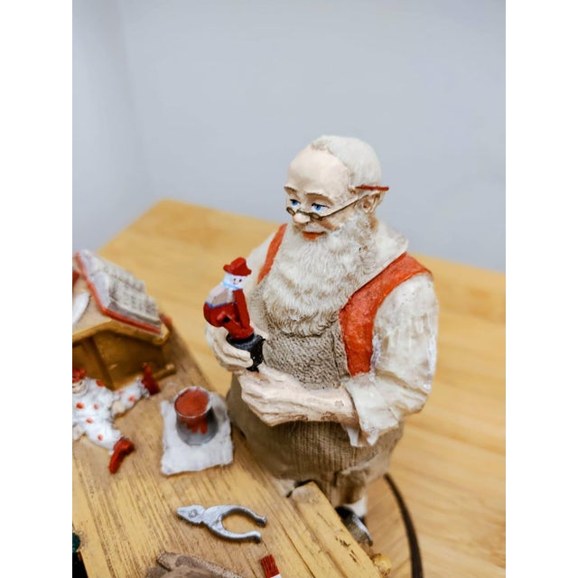 An impressive depiction of Santa's workshop, featuring the workbench, the gift list book, and the toys—all beautifully...