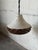 Featuring a flared shade with heavy relief texturing and perforated cutouts along the body, this pendant light provides...