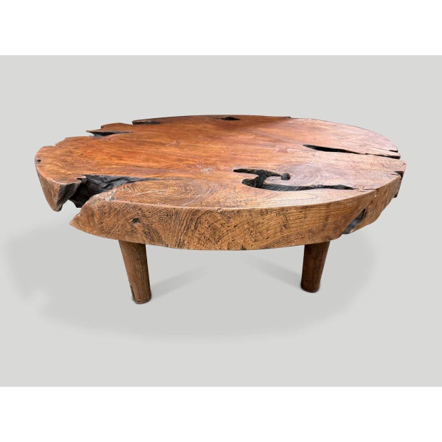 Impressive ancient teak wood coffee table floating on mid century style cone legs and finished with a natural oil...