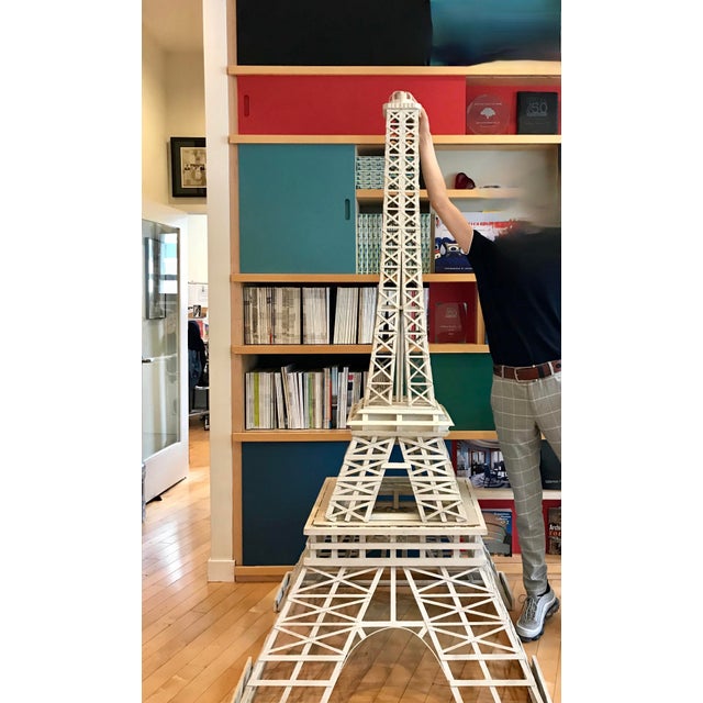 A handmade 123 to 1 scale model of the Eiffel Tower consisting of 783 pieces of wood. Together with the original newspaper...