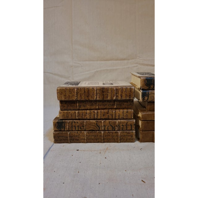 Decorative books in a rich, vibrant gold finish, white parchment, and antique script on cream and brown parchment. The...
