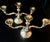 This set features a pair of elegant, multi arm silver-plated candelabras reflecting a distinct mid-century French...
