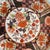 A striking 10 1/4” vintage Japanese Imari plate featuring bold floral panels, a scalloped rim, and the classic Imari...