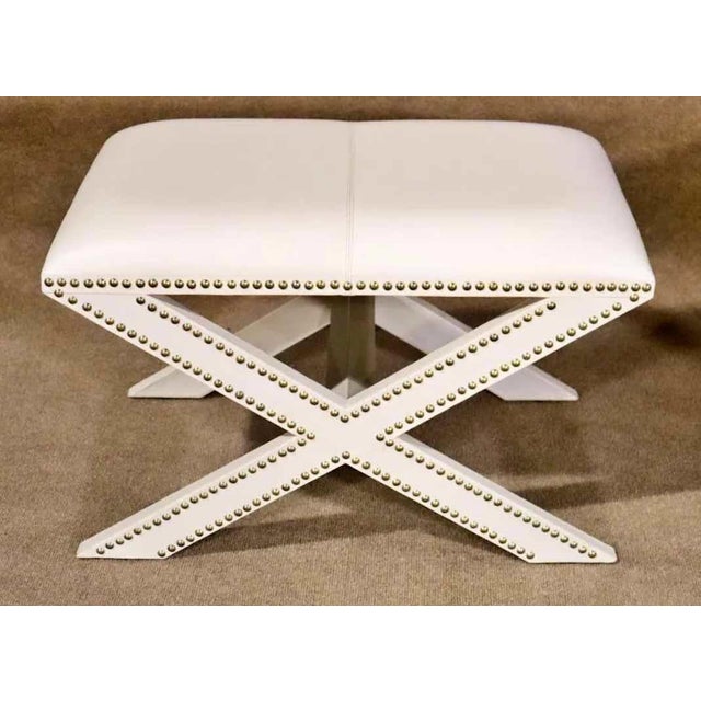 Mid-Century Modern style benches with criss-cross x-frames. Leather covered with exposed nail heads.