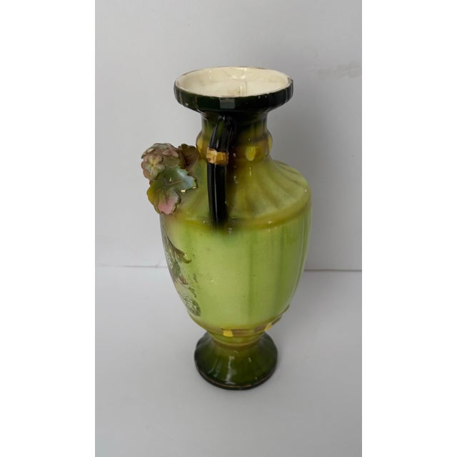 A richly glazed antique majolica-style vase dating to the late Victorian–Edwardian period. Featuring twin loop handles,...