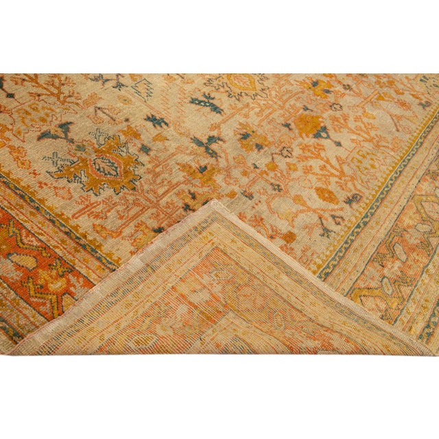 Beautiful vintage Turkish hand-knotted wool rug with a beige field. This rug has accents of orange and peach in a gorgeous...