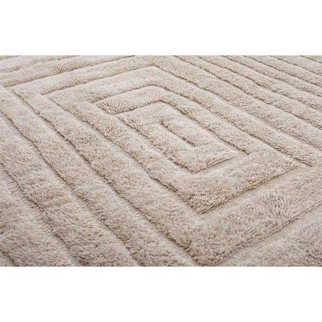 Elegant hand-knotted wool rug in Warm Sand, featuring a layered geometric pattern that exudes subtle depth and texture....