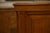 An imposing piece of antique wooden cabinet, featuring straight lines, molded panels, slightly fluted uprights, and a...