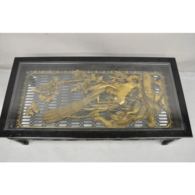 Vintage Chinese Relief Carved Ho ho Bird Glass Top Display Black and Gold Oriental Coffee Table. Item features solid wood...