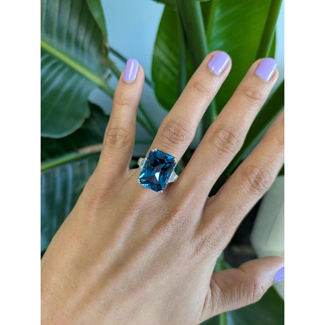 A remarkable 16.87-carat London blue topaz pools with deep, inky blue at the center of this solid 14K yellow gold ring,...
