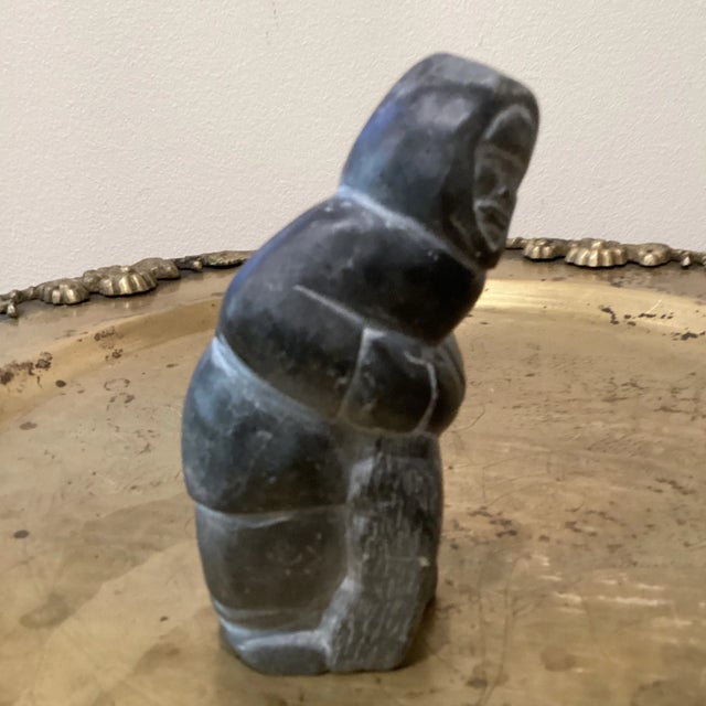 An Inuit style carved by hand of dark soapstone .The sculpture is numbered on the bottom 779