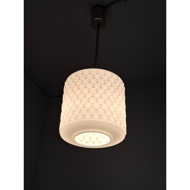 This midcentury modern pendant lamp was produced in czechoslovakia during the 1970s. The design features a cylindrical...