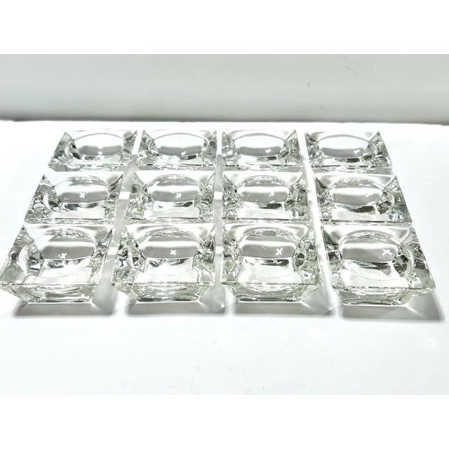 A substantial set of 12 vintage clear glass salt cellars with crisp square exteriors and circular wells. Their compact...