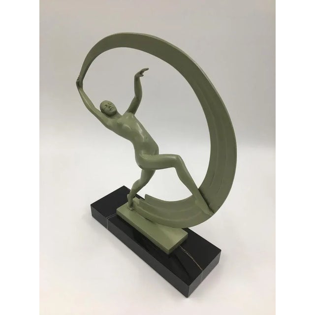 The amazing female figurine is represented in a graceful reclining motion with drapery curving behind her, forming an...