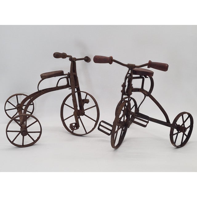 A unique pair of decorative, miniature tricycles made of metal and wood. Both models feature metal, three-dimensional...