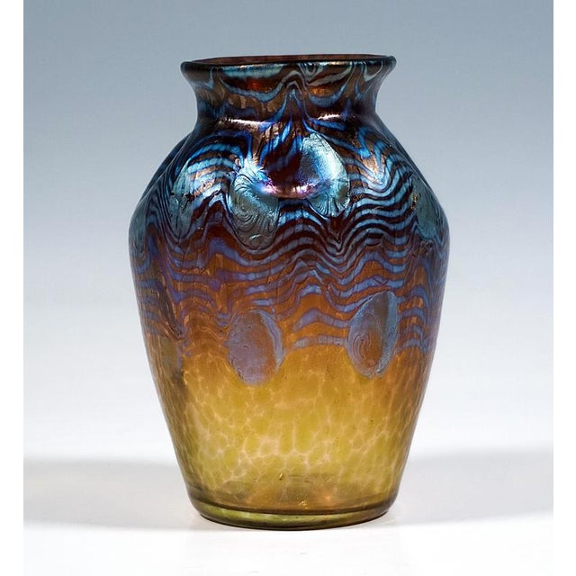 Mould blown, conically widening body on a flush round base, forming rounded shoulders, neck constriction with flared rim,...