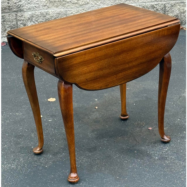 Beautiful solid cherry end table by Statton. Features dropleaf construction, Queen Anne legs, single drawer with original...