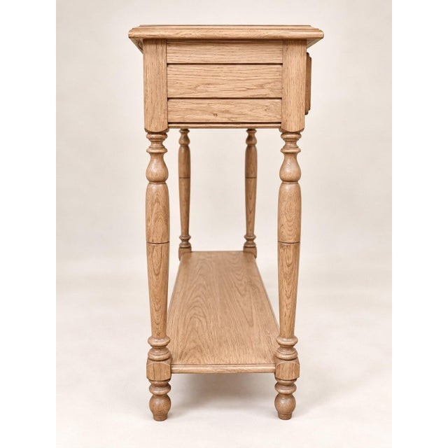 A louis-philippe style console table with two drawers and a lower shelf, crafted by a cabinetmaker in the 1980s from solid...