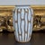 Striking vintage Japanese stoneware vase featuring a dramatic drip glaze design with cascading white glaze over a warm...