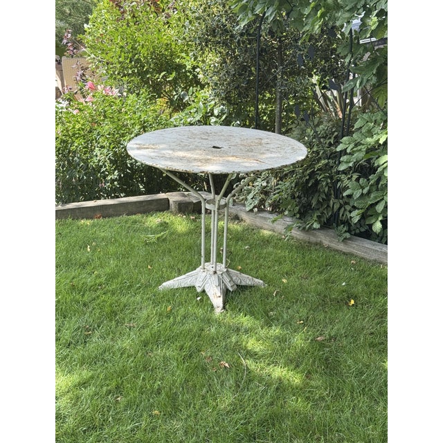 A rare and unique bistro table with wonderful patina and timeworn look showing the Louis Vuitton Paris badge on the foot....