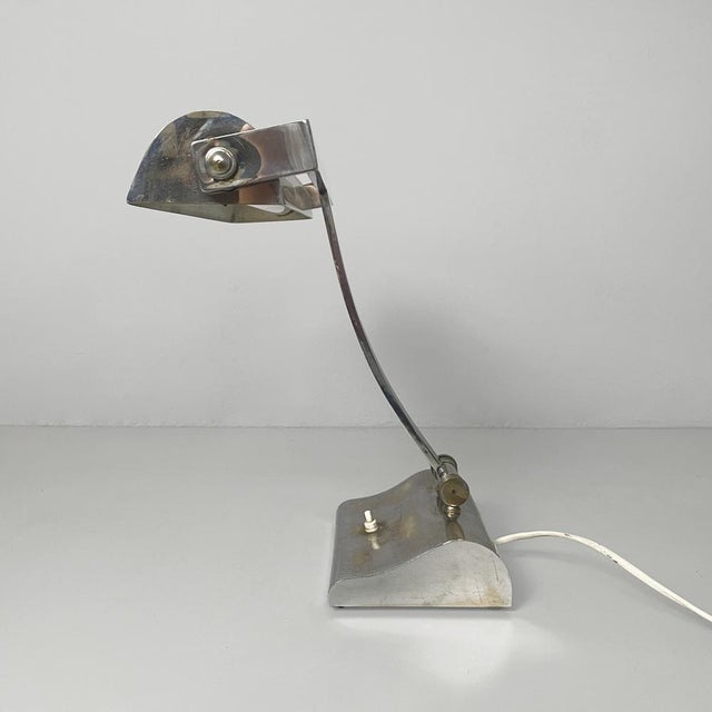 Italian Art Deco table lamp in chromed brass, 1930s Chrome-plated brass table lamp. The elongated and slightly curved...