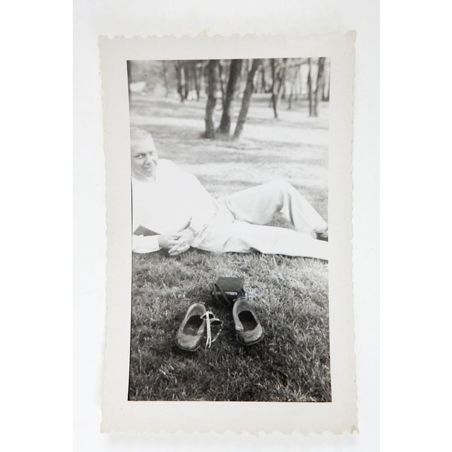 Mid 20th century black and white snapshot photograph of man in park whose girlfriend has left leaving sunglasses and...