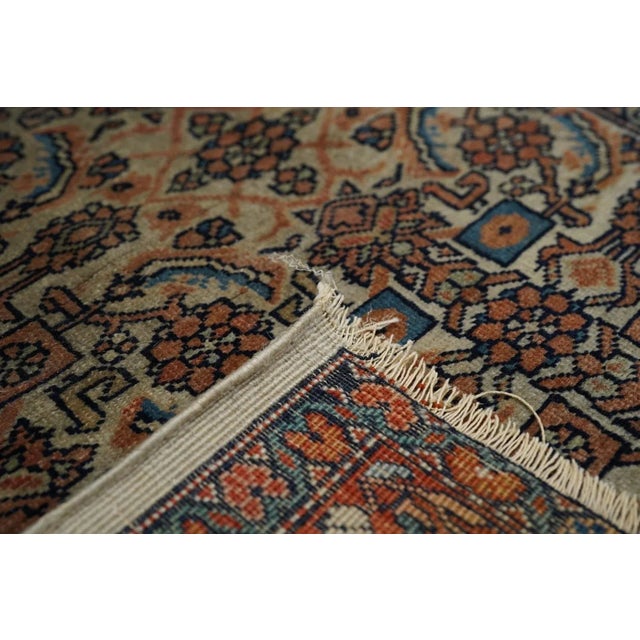 This antique west Persian village scatter features an straw-ecru field totally covered with a medium-scale Herati design....
