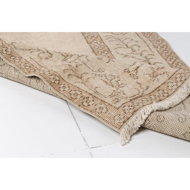 This is a vintage Turkish Oushak rug from the Mid 20th Century. The piece was hand-knotted.