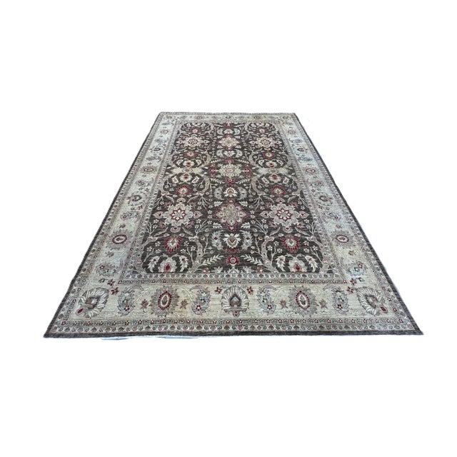 Afghan Oushak rug, hand-knotted in Afghanistan from 100% wool. Measuring 9’10” x 13’10”, the rug features an elegant...