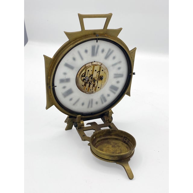 A small night travel clock, designed to be lit by a candle placed in the back compartment, allowing the time to be read in...