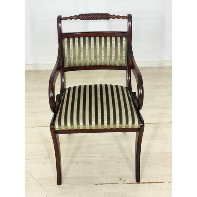 Elegant set of two vintage dining chairs from the 1960s. The chairs impress with their curved armrests, decorative...
