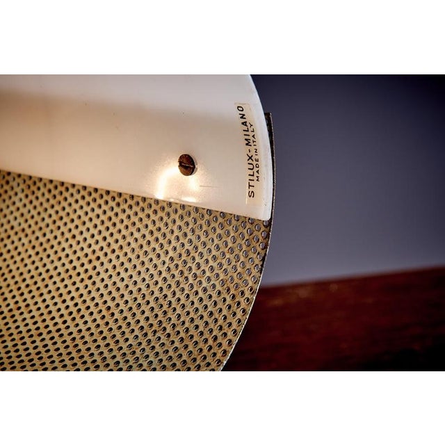 A pair of mid-century table lamps by stilux milano, each with a cylindrical shade made from perforated metal and a smooth...