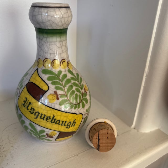 Vintage ceramic whiskey decanter featuring a beautifully aged crackle glaze and hand-painted scroll motif, evoking the...