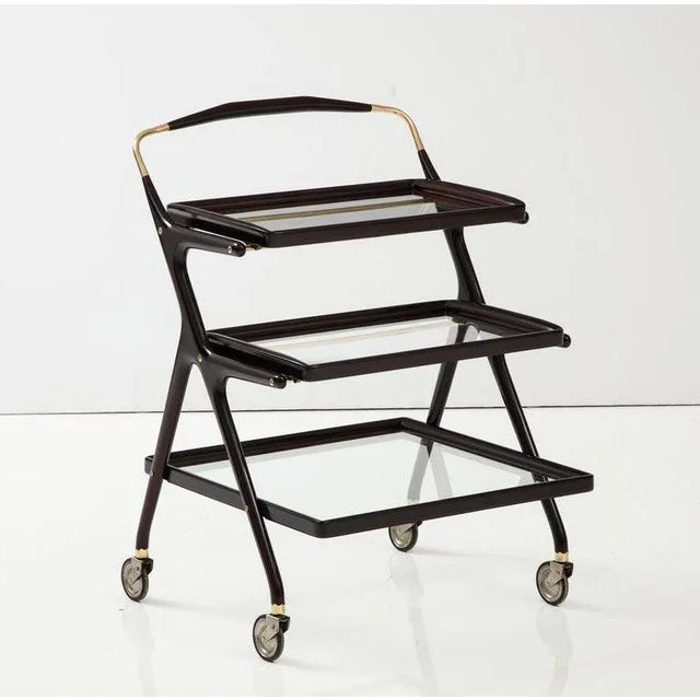 1950's Modernist 3 tier mahogany and brass bar cart designed by Cesare Lacca the top top trays are removable, fully...