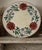 A charming antique European earthenware charger dating to the late 19th or early 20th century. Hand-painted with bold red...