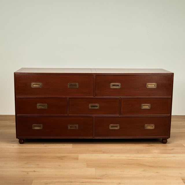Chic mid century chest crafted in mahogany with seven asymmetrical drawers for plenty of storage, brass campaign style...
