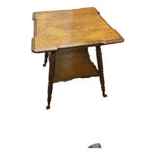 Early 20th Century Antique Tiger Oak Center Claw Foot Table With Shelf For Sale